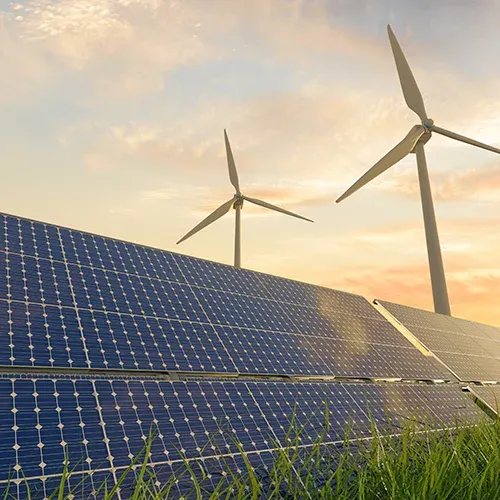 turbines and solar panels at sunset