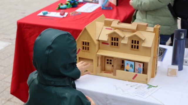 childlooking into a dollhouse