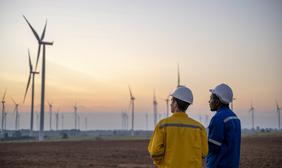 Two people overlooking wind turbines.