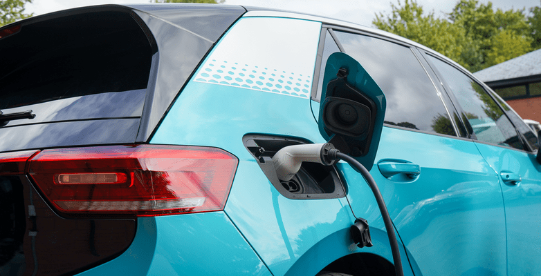 Blue Electric Vehicle recharging in a neighborhood